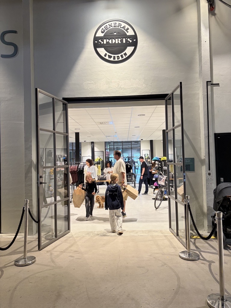 Entrén till General Sports med kunder på väg ut
