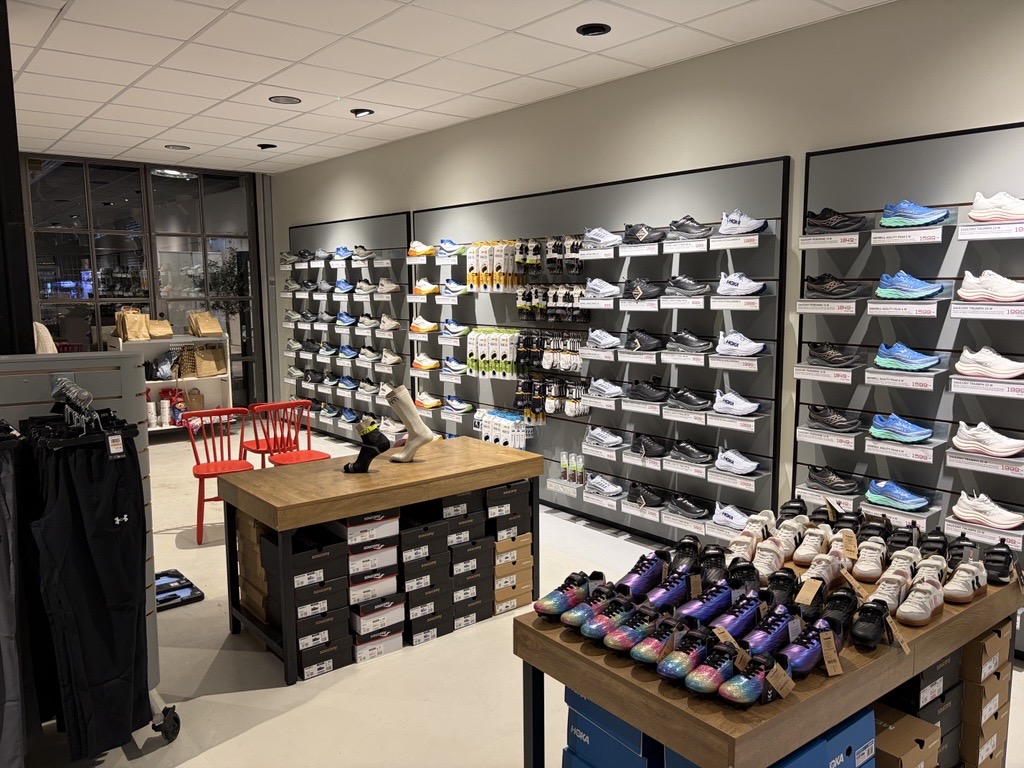 Skovägg med löparskor från Hoka och Saucony